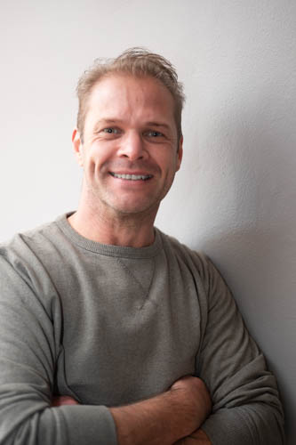 Man wearing a green top smiling.